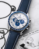 Omega Speedmaster blue chronograph watch with Snoopy illustration on the dial, blue fabric strap, on cartoon-themed background