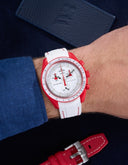 Red and white rubber strap on Omega x Swatch MoonSwatch Mission to Mars watch, worn on wrist